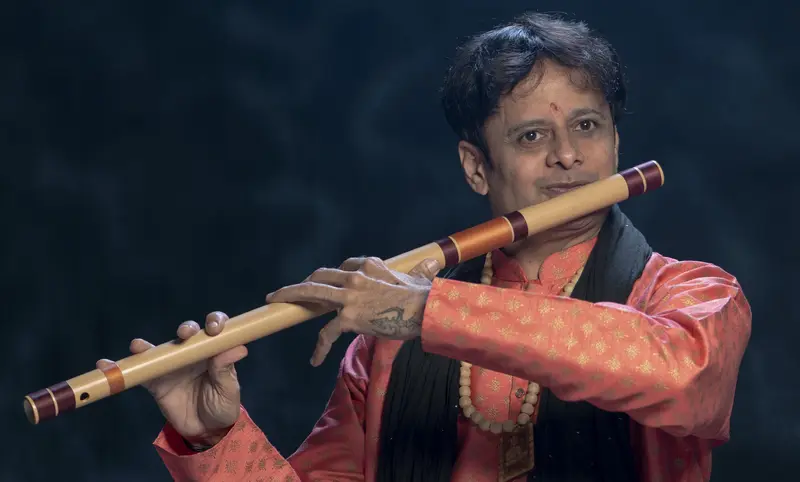 Prakash Hegde playing the bansuri in a coral kurta