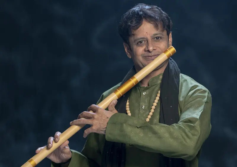 Prakash Hegde playing the bansuri in a green kurta
