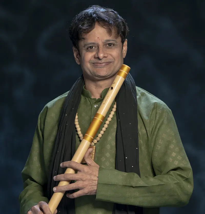 Portrait of Prakash Hegde with a bansuri in a green kurta