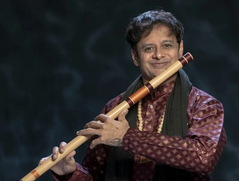 Prakash Hegde playing the bansuri in a maroon kurta