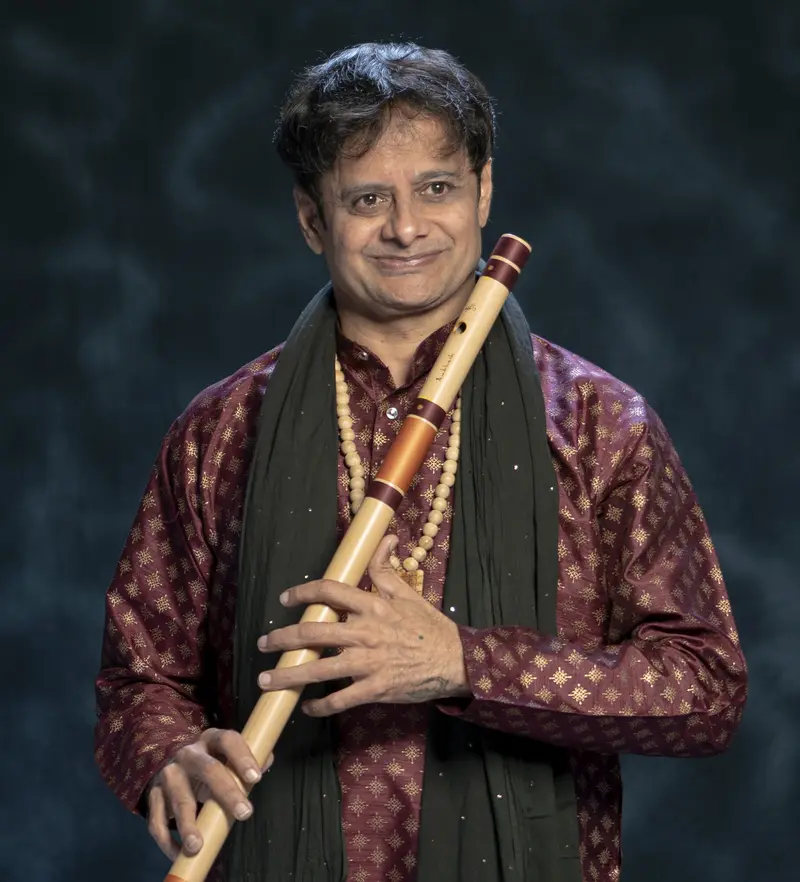 Prakash Hegde holding a bansuri in a maroon kurta